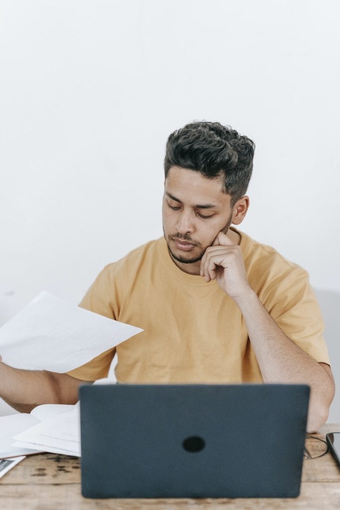 Busy man working with laptop and documents