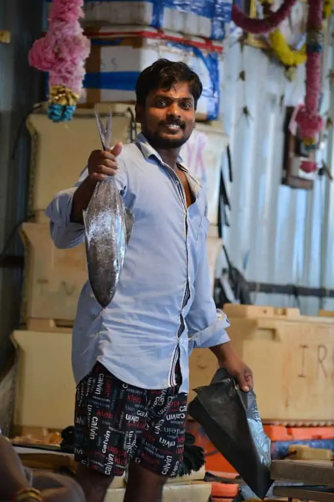 man in white long sleeve shirt holding fish
