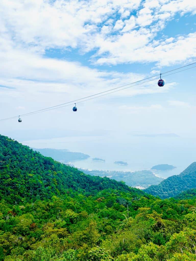 cable cars over green mountains during daytime