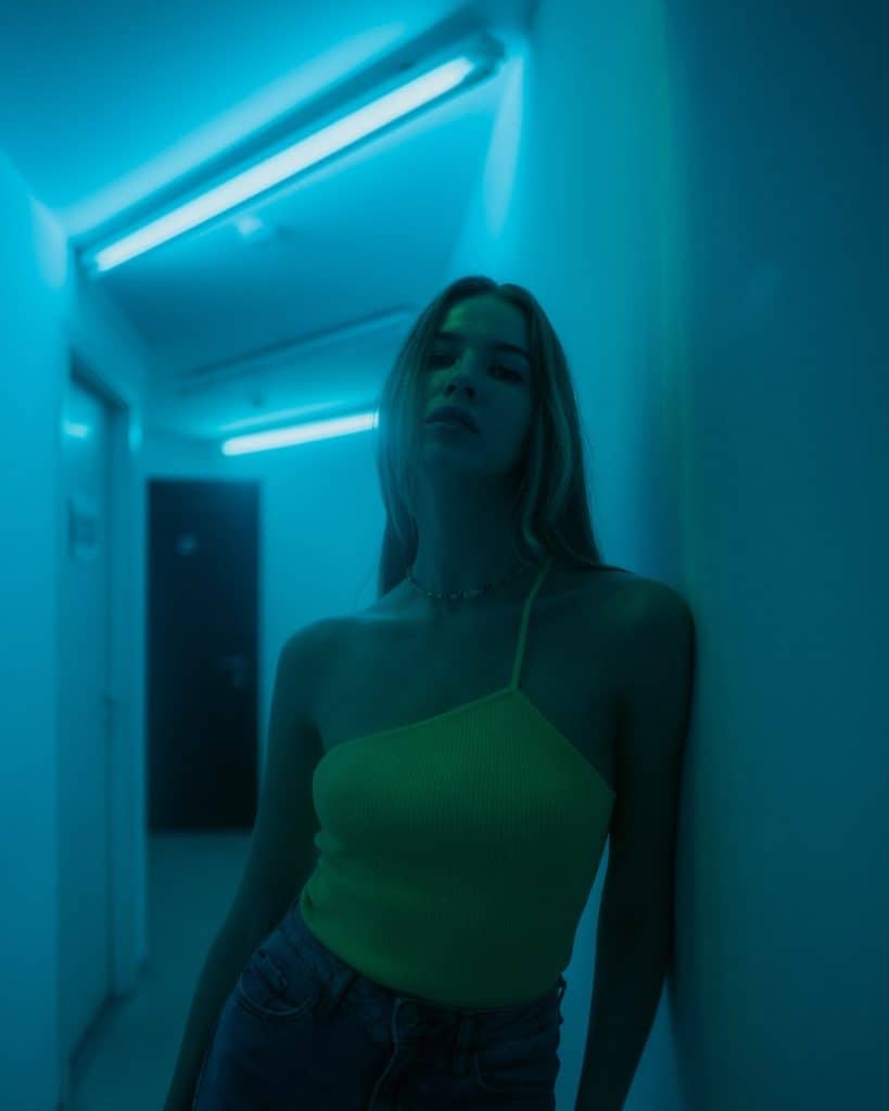 a woman in a yellow top standing in a hallway